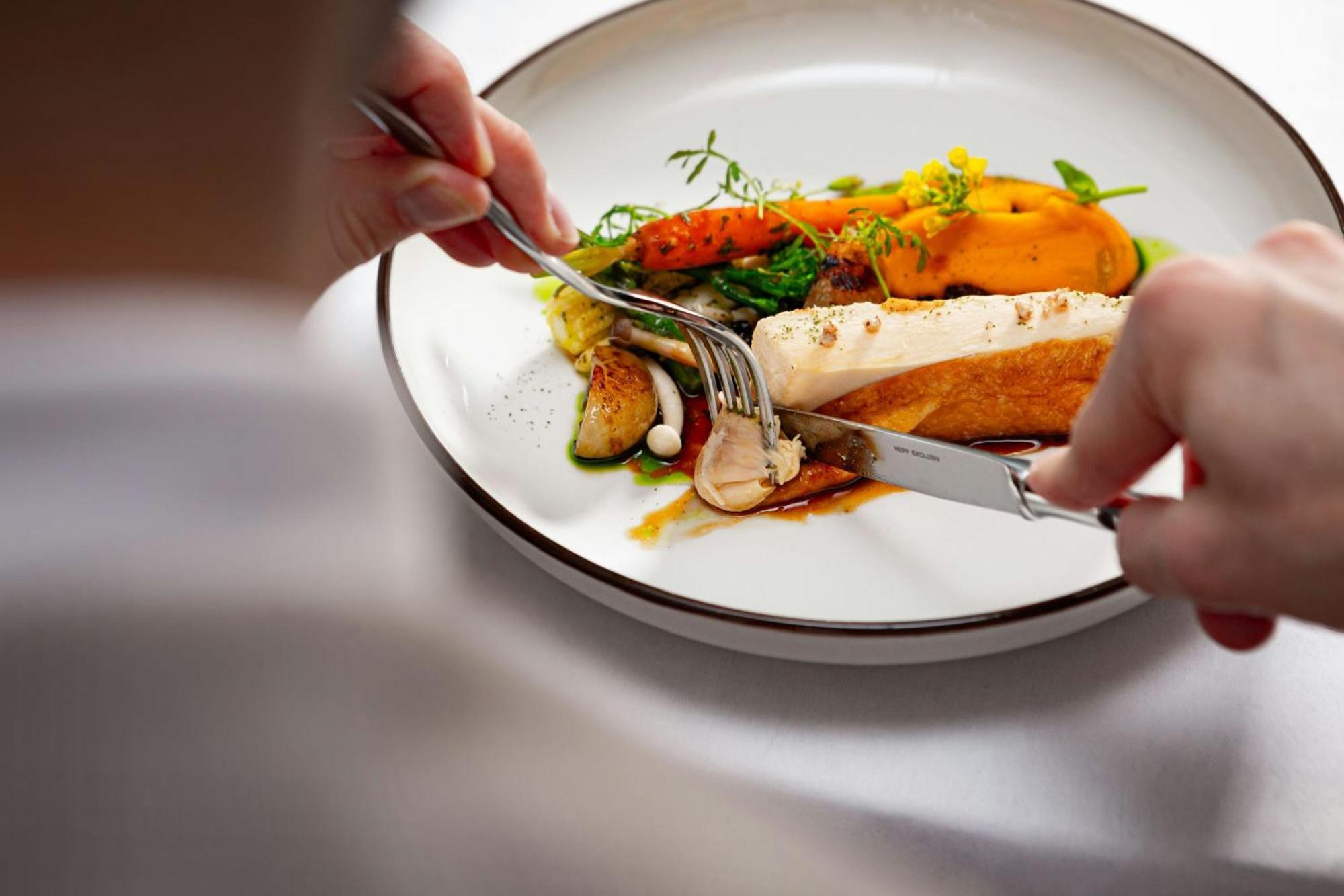 河滨公园大酒店-奢华精选 布拉迪斯拉发 外观 照片 A person using a knife and fork to cut into a meal
